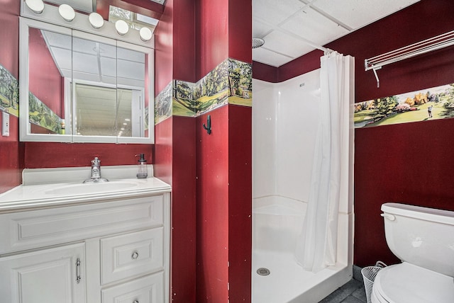 bathroom featuring a stall shower, a paneled ceiling, vanity, and toilet