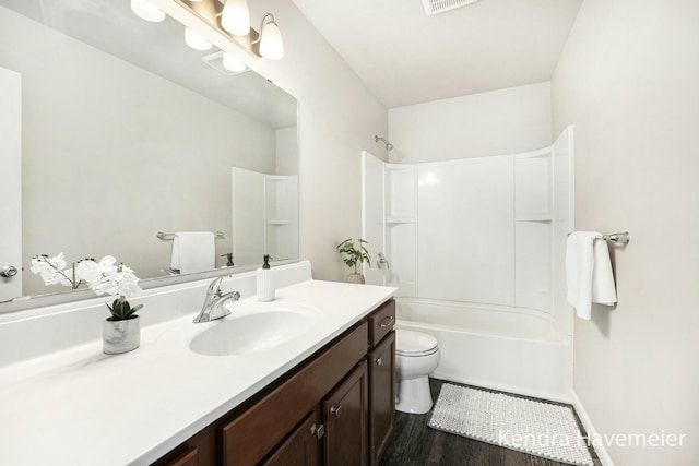 bathroom with toilet, wood finished floors, visible vents, bathing tub / shower combination, and vanity