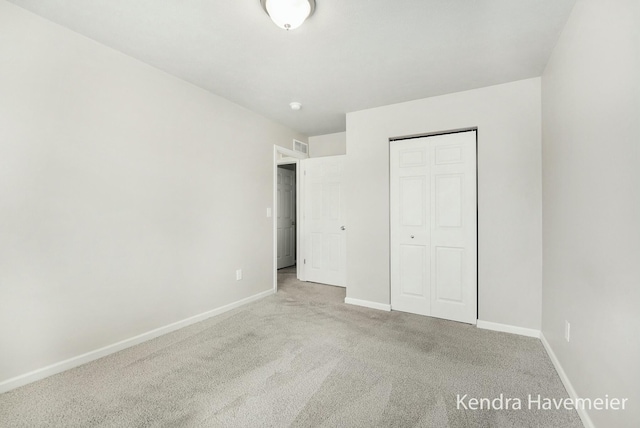 unfurnished bedroom featuring a closet, carpet, visible vents, and baseboards