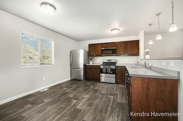 kitchen with dark wood-style floors, stainless steel appliances, visible vents, a sink, and baseboards