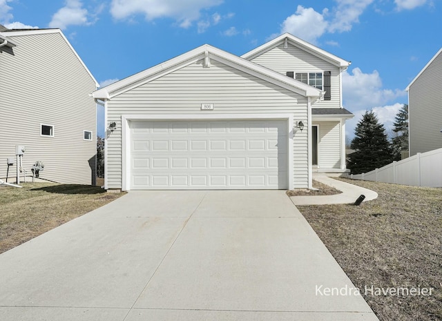 traditional home featuring a garage, concrete driveway, and fence