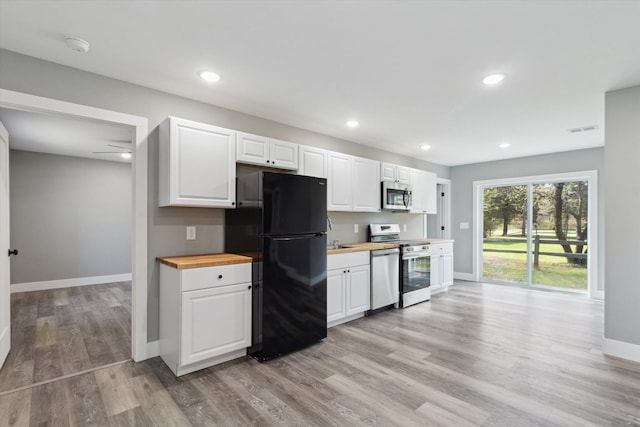 706 Colfax St, Cadillac, MI 49601 - kitchen with appliances with stainless steel finishes, butcher block countertops, baseboards, light wood-style flooring, and white cabinetry