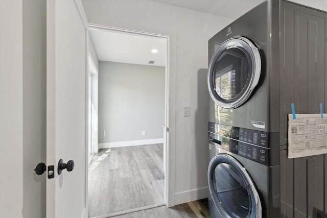 706 Colfax St, Cadillac, MI 49601 - laundry area featuring stacked washer / dryer, wood finished floors, and baseboards