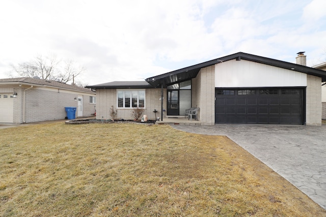 mid-century modern home with a garage, a front yard, brick siding, and driveway