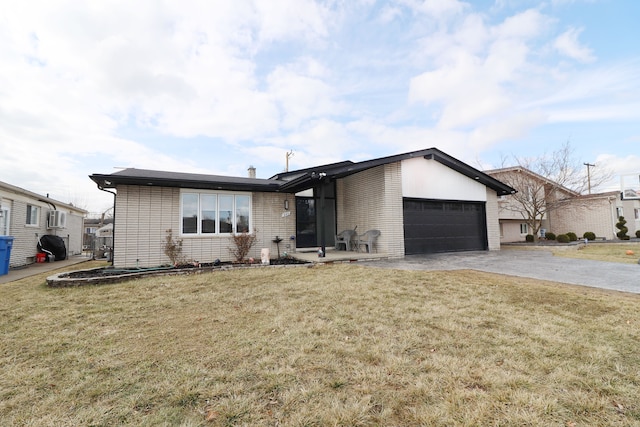 mid-century modern home with driveway, a front lawn, an attached garage, and brick siding