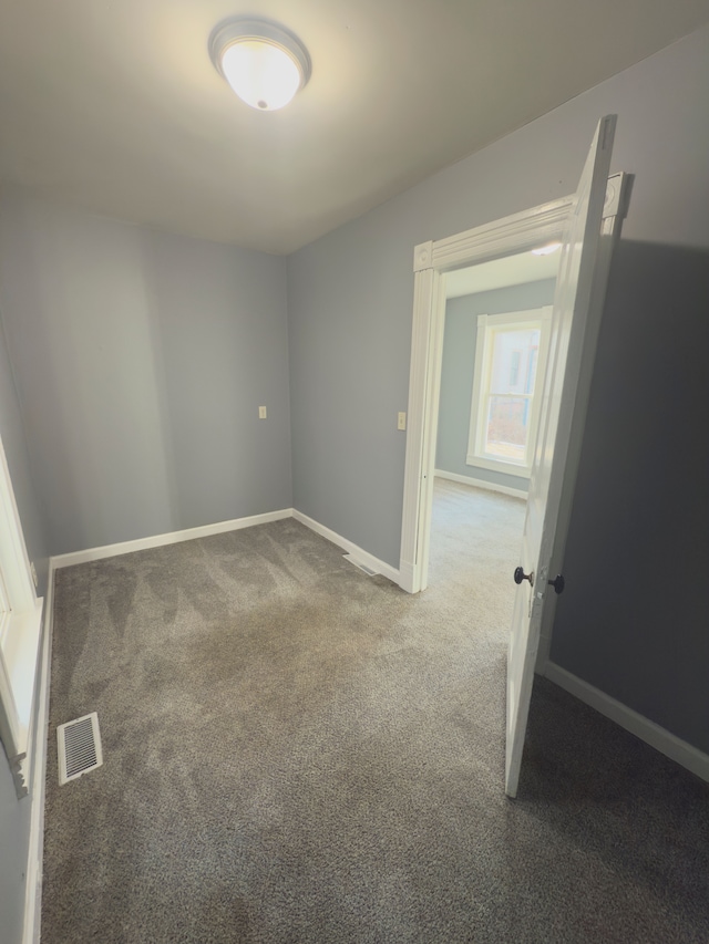 carpeted empty room with visible vents and baseboards