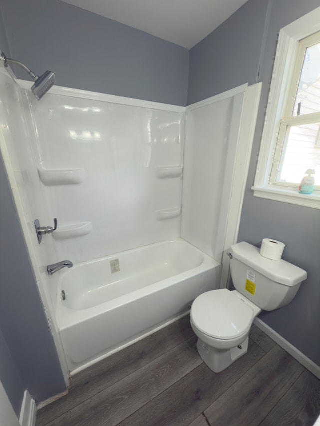 full bathroom with baseboards, toilet, wood finished floors, and bathtub / shower combination