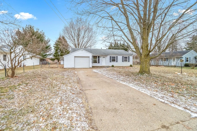 ranch-style house with a garage, fence, and driveway