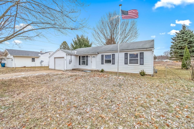 ranch-style house with a garage, concrete driveway, and fence