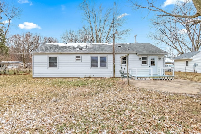 back of property with a shingled roof and a patio area