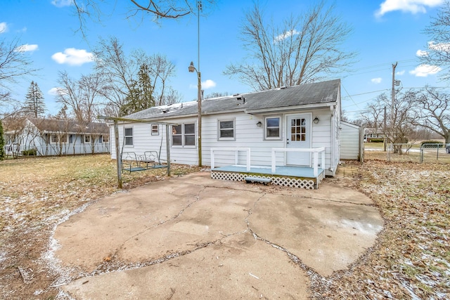 rear view of house featuring a deck, a yard, a patio, and fence