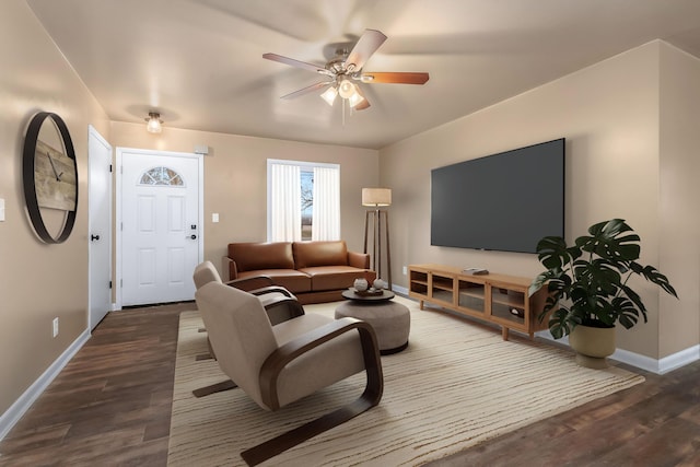 living room featuring dark wood-type flooring, ceiling fan, and baseboards