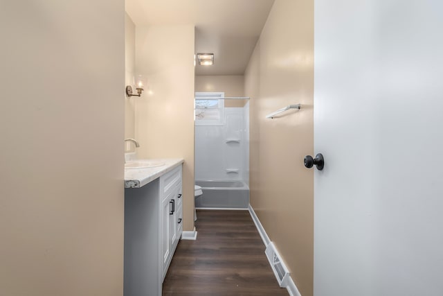 bathroom with visible vents, toilet, vanity, wood finished floors, and baseboards