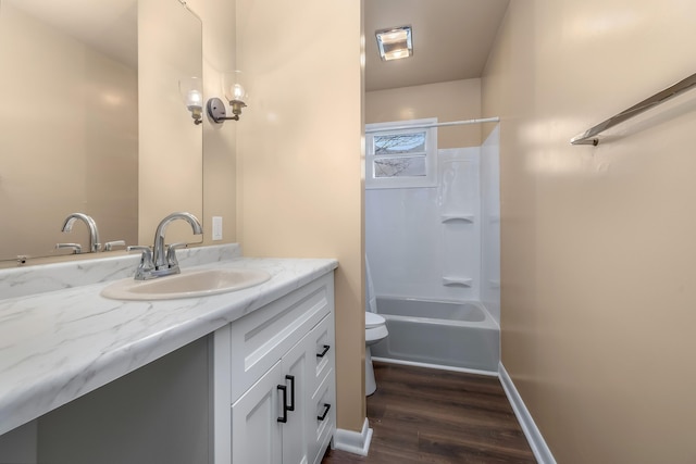 full bathroom with bathtub / shower combination, toilet, vanity, wood finished floors, and baseboards