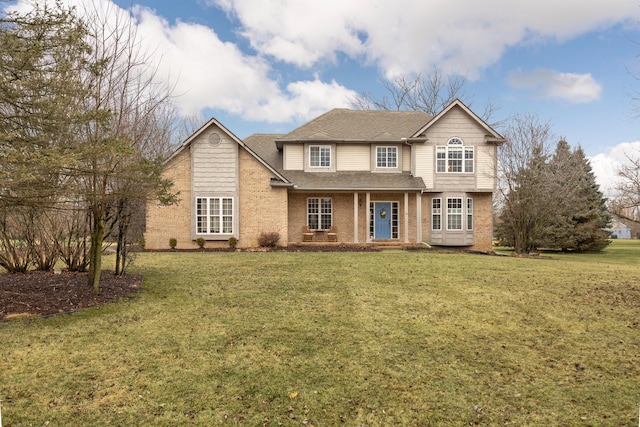 traditional home with brick siding, roof with shingles, and a front yard