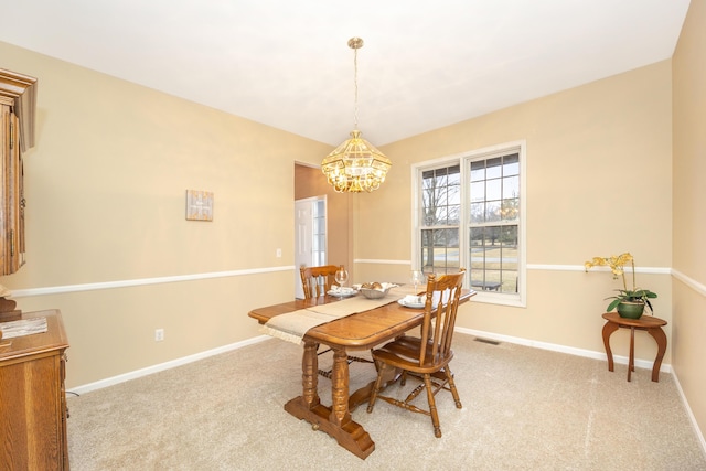 carpeted dining room with a chandelier, visible vents, and baseboards