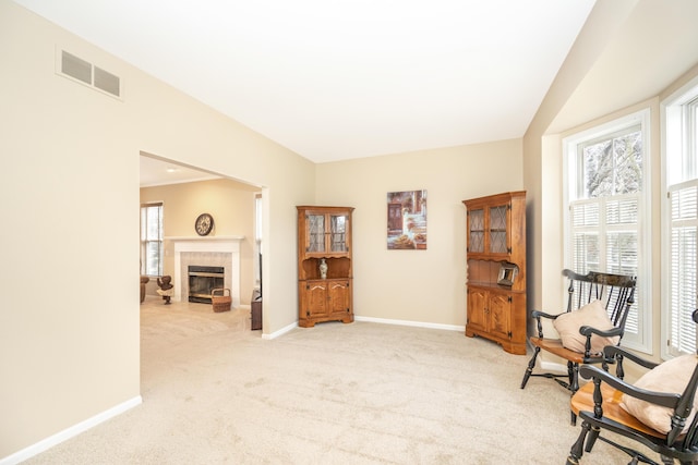 sitting room featuring carpet, baseboards, a fireplace, and visible vents