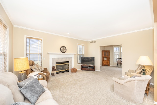 living area with a healthy amount of sunlight, visible vents, carpet flooring, and ornamental molding