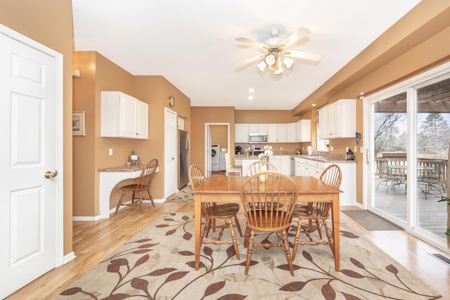 dining space featuring baseboards, a ceiling fan, built in study area, washer and dryer, and light wood-style floors