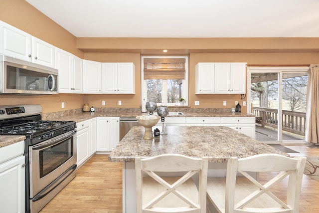 kitchen featuring appliances with stainless steel finishes, a breakfast bar, and white cabinets