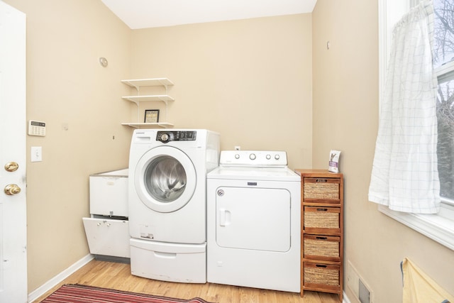 laundry room featuring light wood-style flooring, laundry area, washer and clothes dryer, and baseboards