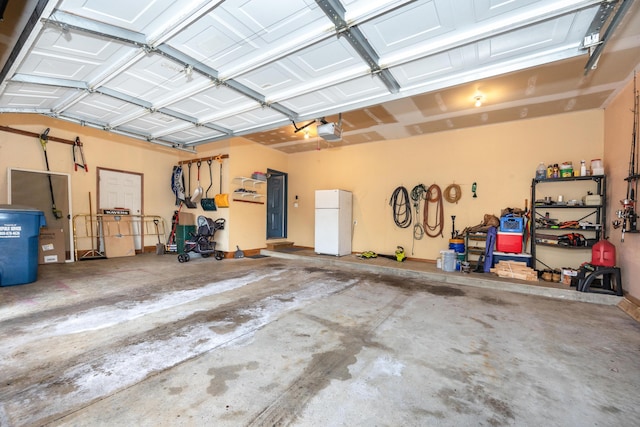 garage featuring a garage door opener and freestanding refrigerator