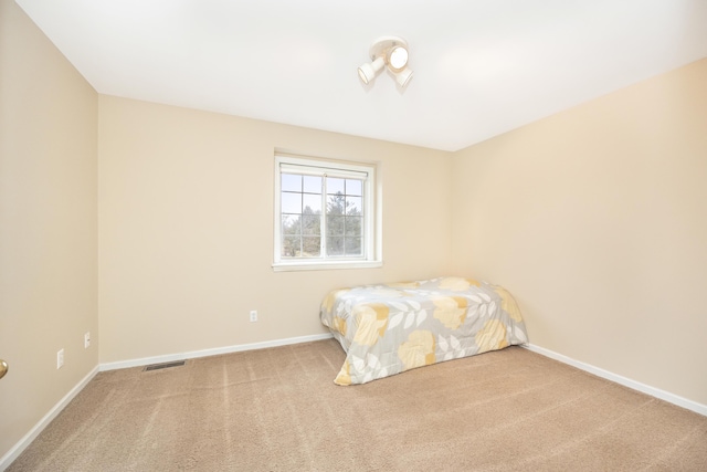 unfurnished bedroom with carpet floors, visible vents, and baseboards