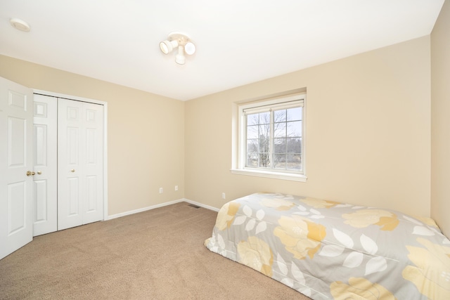 bedroom featuring carpet floors, baseboards, and a closet