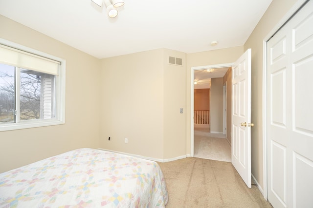 bedroom with light colored carpet, visible vents, and baseboards