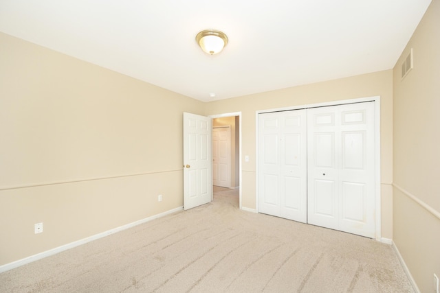 unfurnished bedroom with a closet, carpet flooring, visible vents, and baseboards