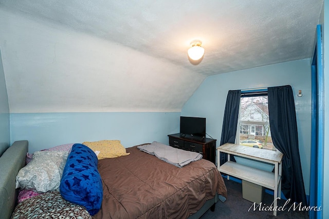 carpeted bedroom featuring lofted ceiling and a textured ceiling