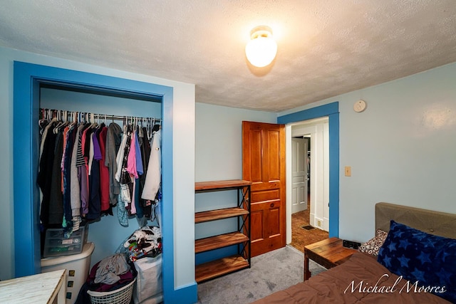 bedroom featuring visible vents, a closet, carpet flooring, and a textured ceiling