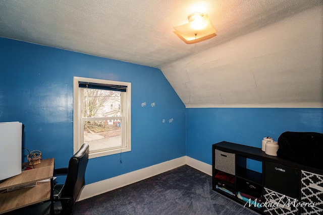 office space featuring dark carpet, vaulted ceiling, a textured ceiling, and baseboards