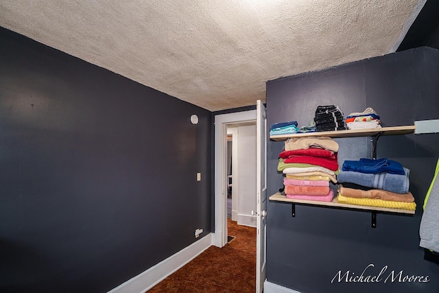 carpeted bedroom featuring a textured ceiling and baseboards