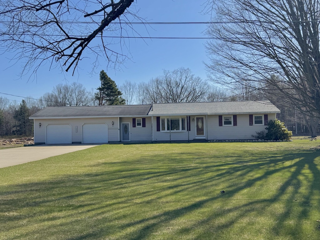 single story home with a front lawn, an attached garage, and driveway