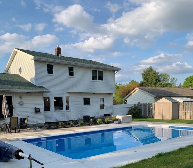 view of pool with a fenced in pool, an outbuilding, a storage shed, a patio area, and fence