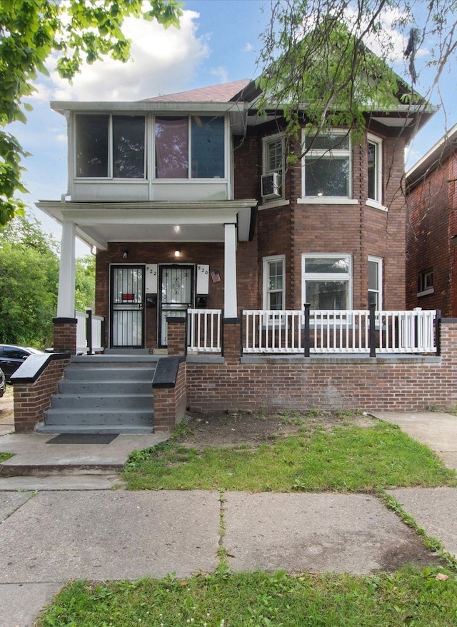 view of front facade with a porch and brick siding