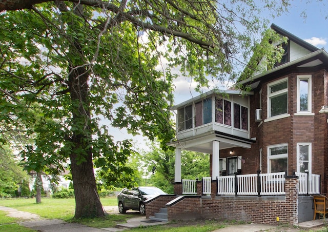 view of home's exterior with covered porch and brick siding