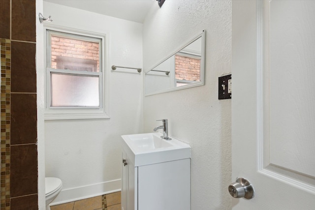 bathroom featuring toilet, tile patterned flooring, baseboards, and vanity