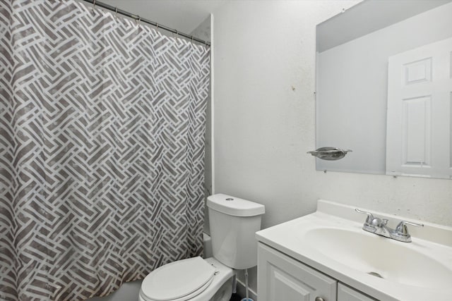 full bath with curtained shower, vanity, and toilet