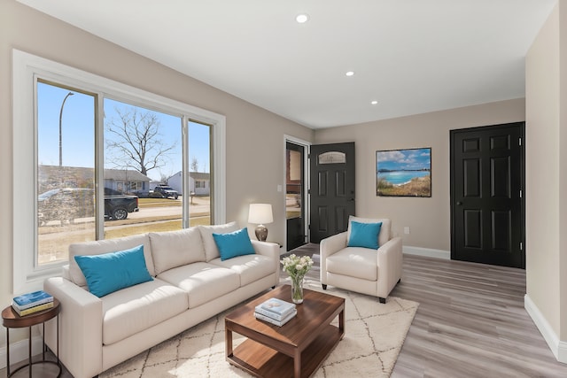 living area with recessed lighting, baseboards, and light wood finished floors