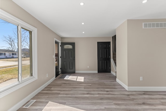 foyer entrance featuring visible vents, baseboards, and a healthy amount of sunlight