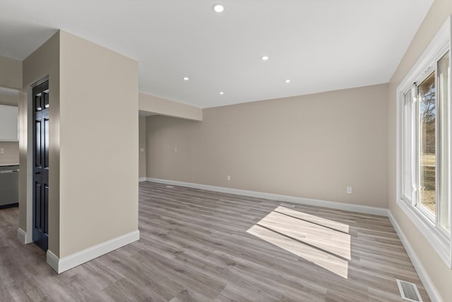 spare room with a wealth of natural light, visible vents, baseboards, and light wood finished floors