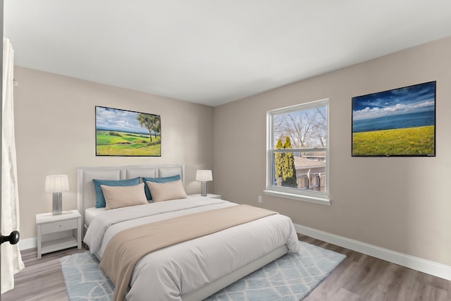 bedroom with wood finished floors and baseboards