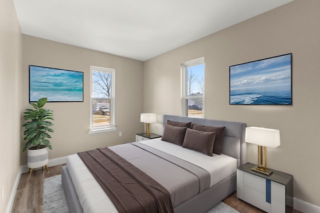 bedroom with wood finished floors and baseboards