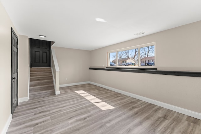 interior space with light wood finished floors, visible vents, stairs, and baseboards