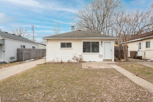 back of house featuring a patio area, a shingled roof, and fence