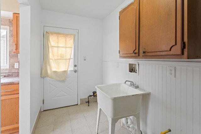 laundry area with light tile patterned flooring, hookup for a washing machine, and cabinet space