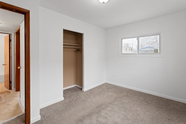 unfurnished bedroom with a closet, carpet, and baseboards