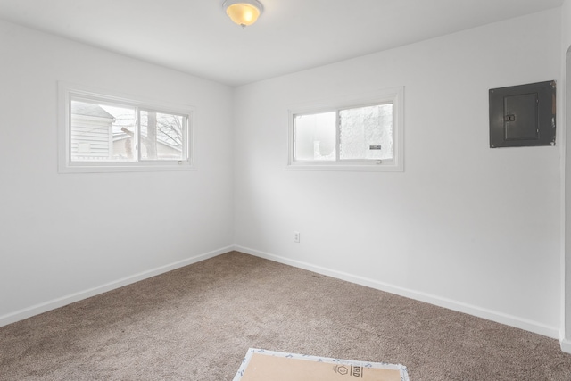 carpeted empty room featuring electric panel and baseboards